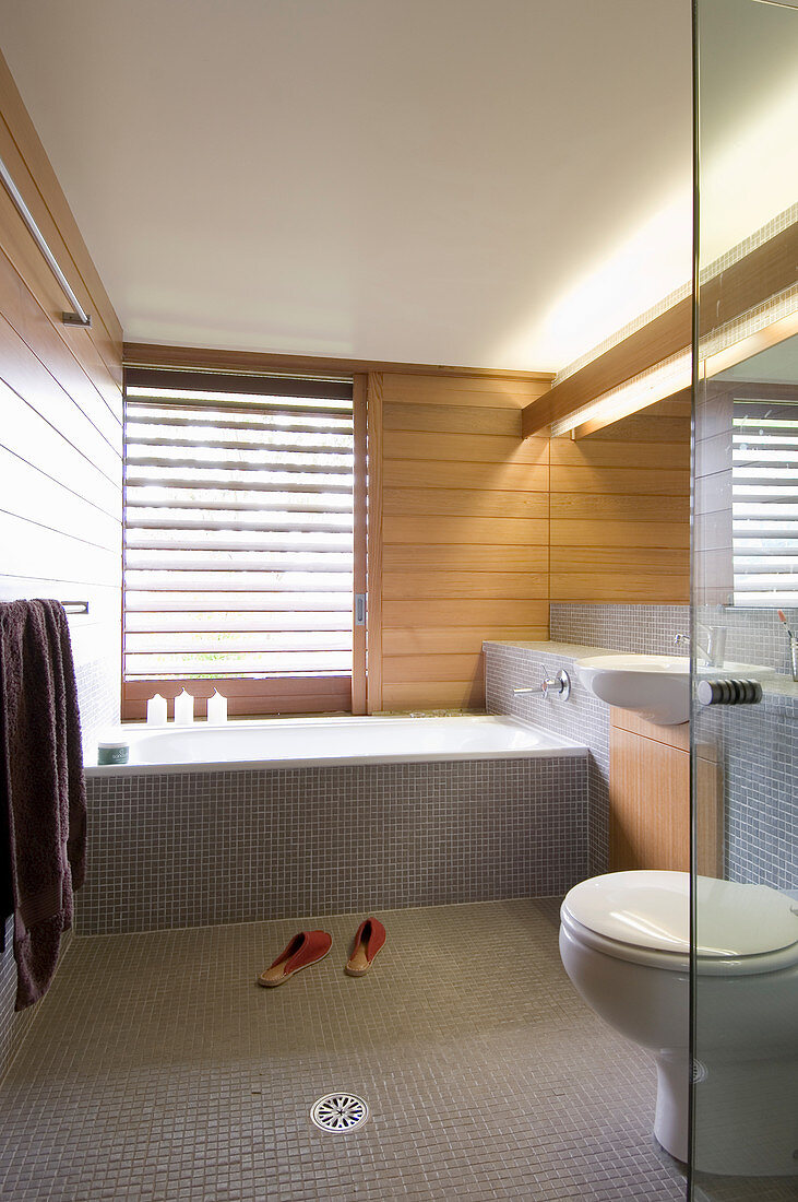 Minimalistisches Badezimmer mit grauen Mosaikfliesen und Holzverkleidung