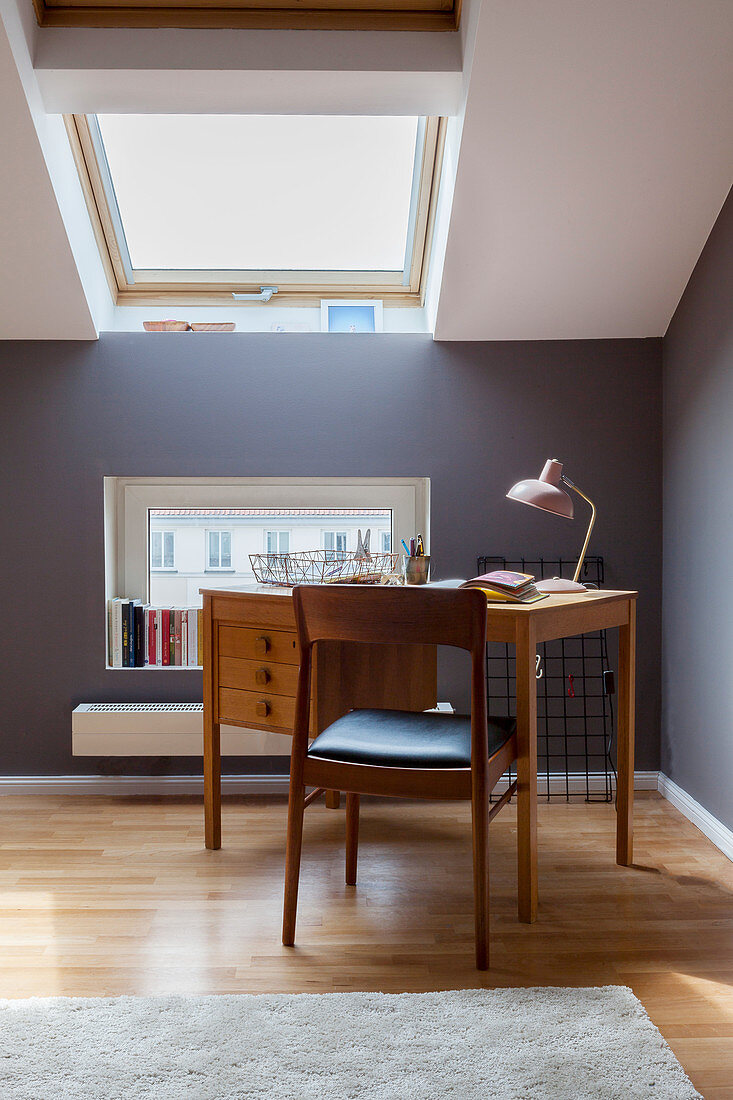 Schreibtisch und Stuhl im Dachgeschoss-Arbeitszimmer mit grauen Wänden