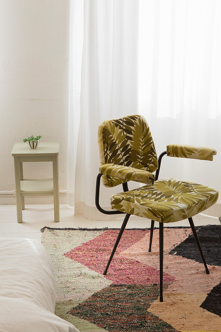 Chair with leaf-patterned upholstery on herringbone rug