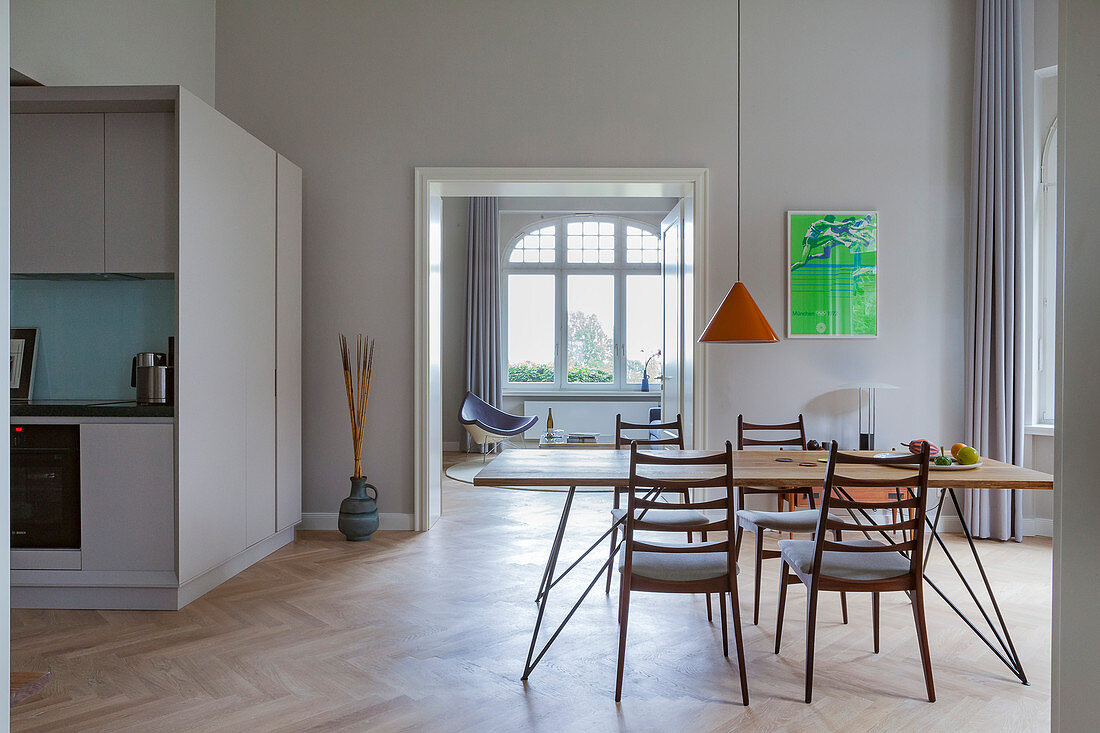 Filigraner Esstisch mit Stühlen in offenem Wohnraum, Küche als maßgefertigter Kubus