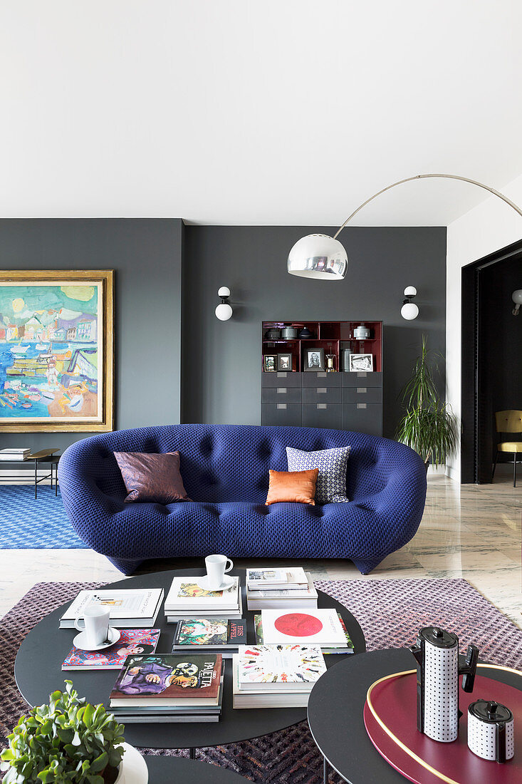 Tiefblaues halbrundes Sofa im Wohnzimmer im Designerstil