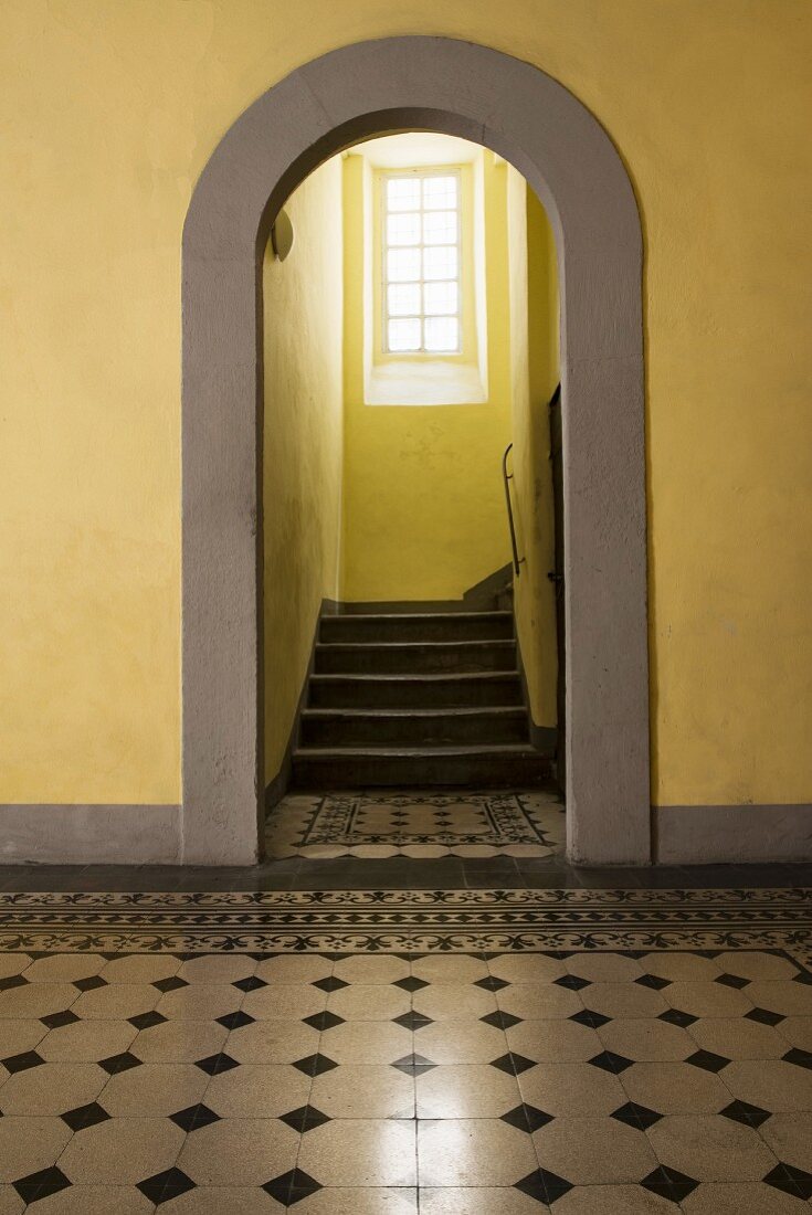 Blick durch Türbogen ins Treppenhaus mit gelben Wänden