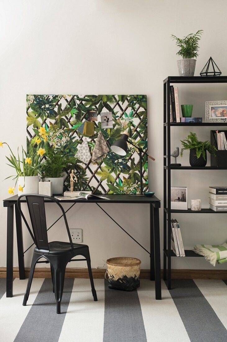 Black furniture and jungle-print pinboard in study