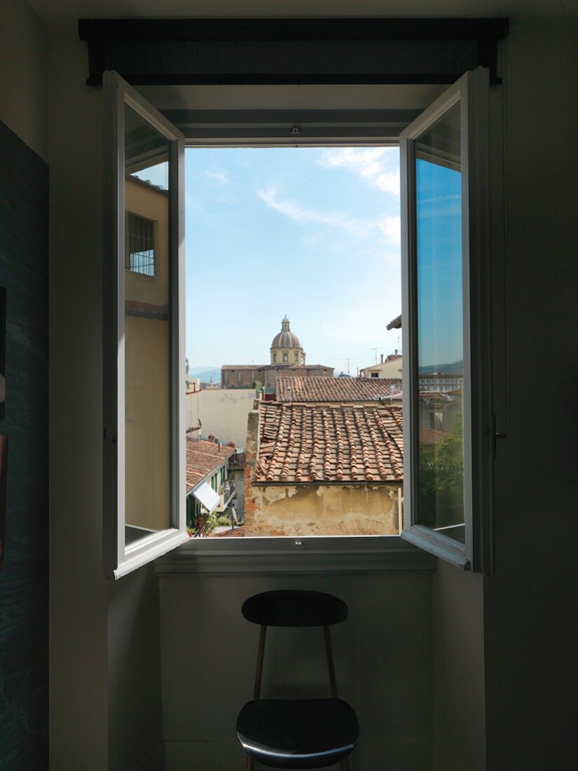 View through open window over the rooftops of Florence