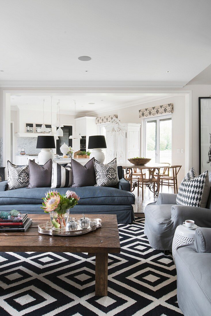Patterned rug and upholstered seating in open-plan interior