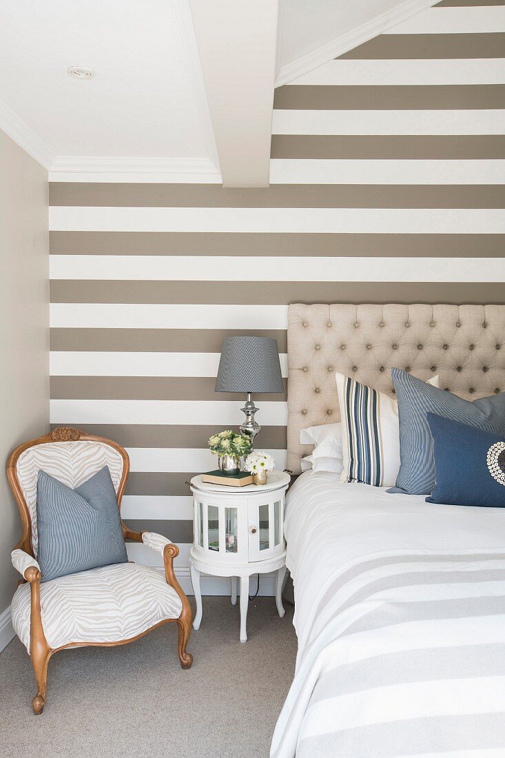 Gestreifte Wand im eleganten Schlafzimmer in Beige, Weiß und Blau