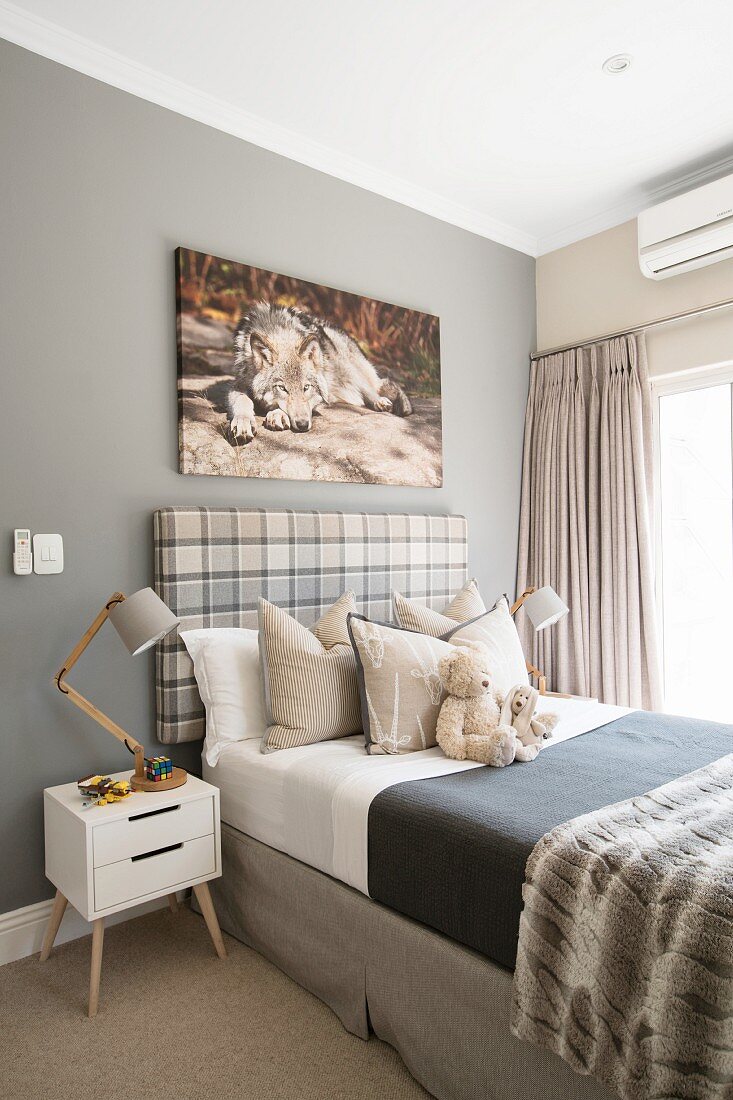 Child's bedroom in natural shades with picture of wolf above bed