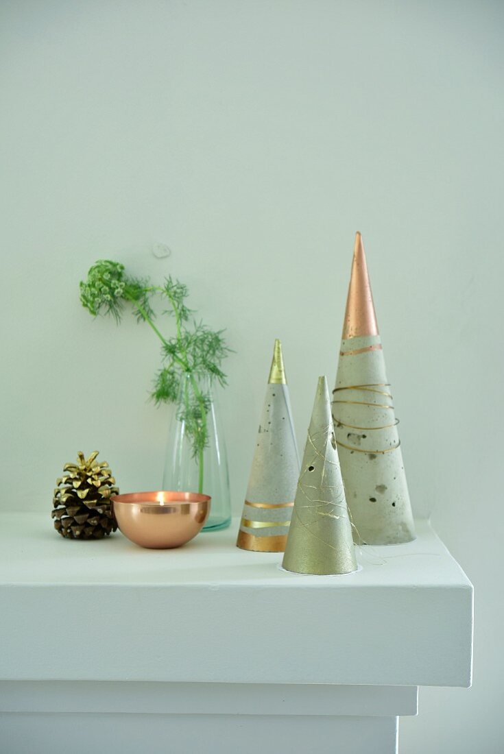 Stylised Christmas trees made from concrete cones with metallic paint