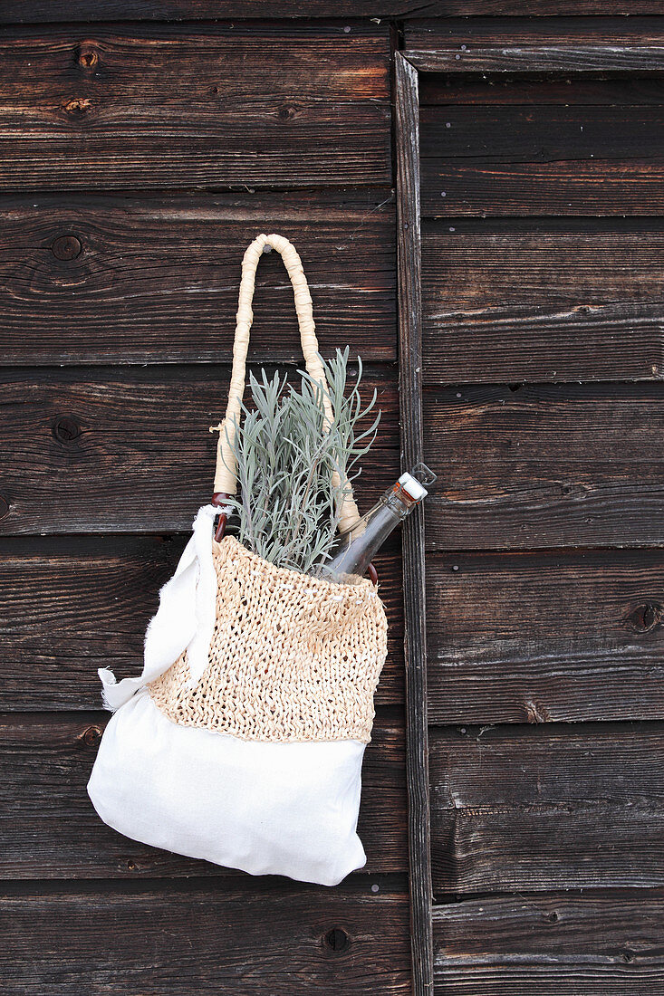 Hand-made cotton and raffia bag hung on wooden wall