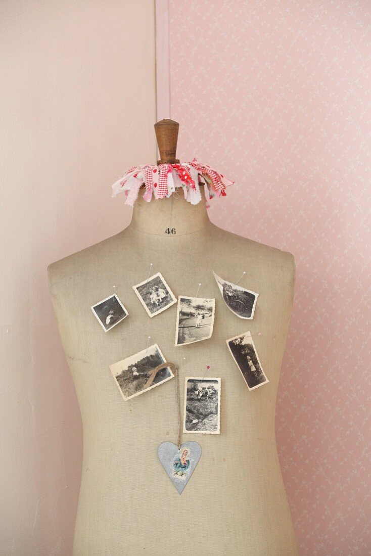 Vintage photos stuck to tailor's dummy with drawing pins