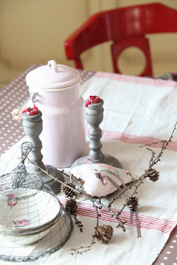 Tischdekoration mit Retro Milchkanne, gedrechselten Kerzenständern und Zapfenzweigen