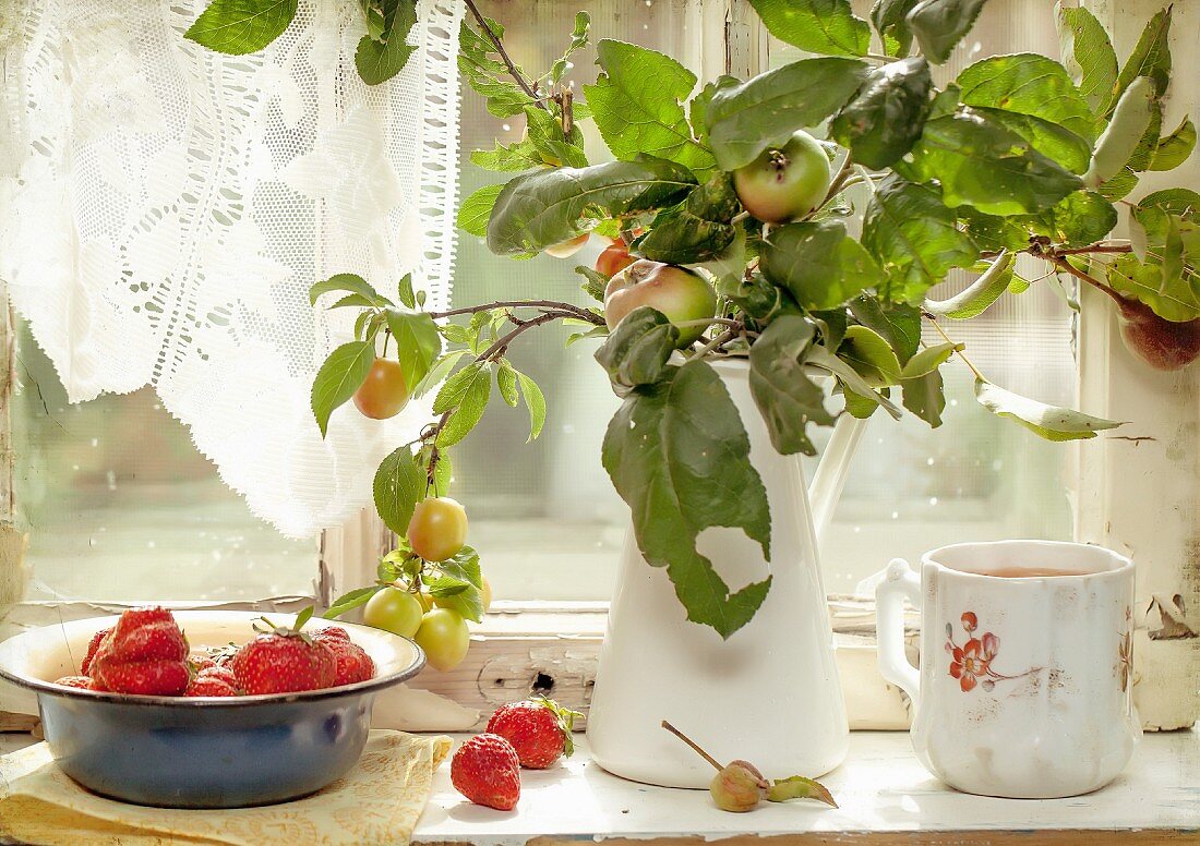 Apples and fresh strawberries on a old windowsill