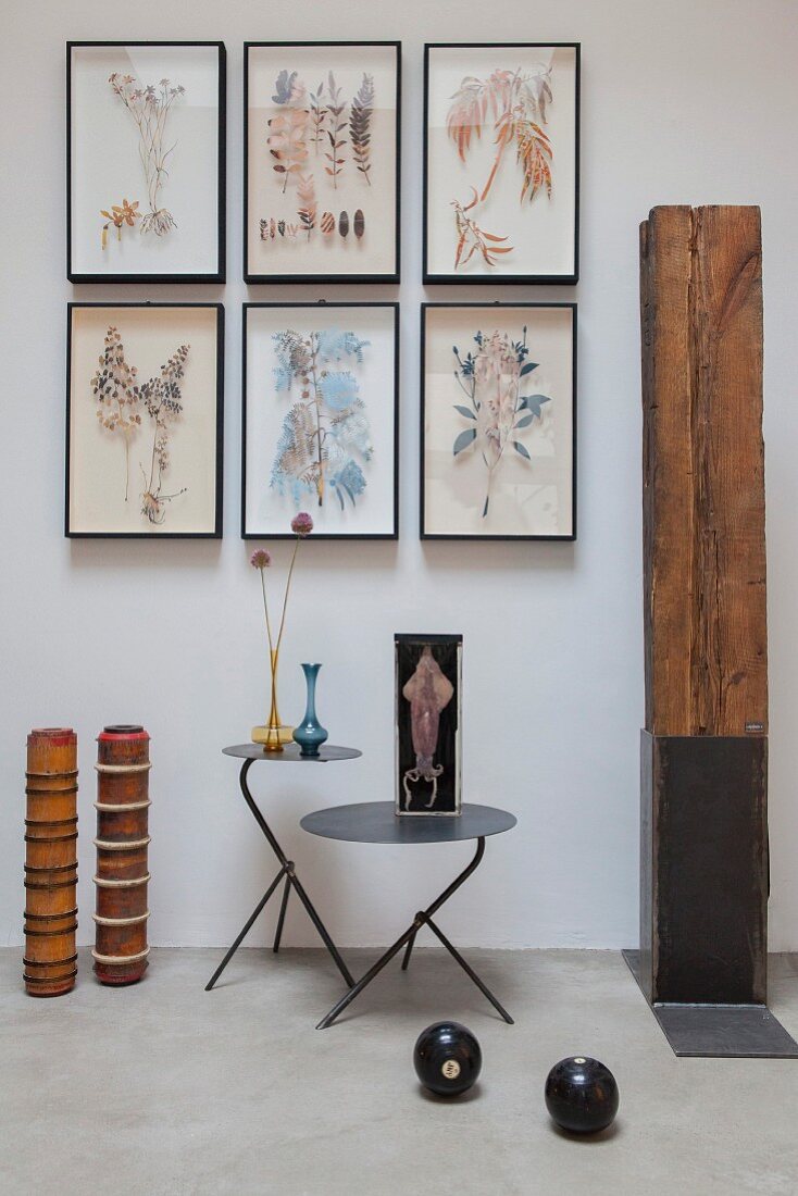 Framed leaves on wall, wooden artworks and metal side tables