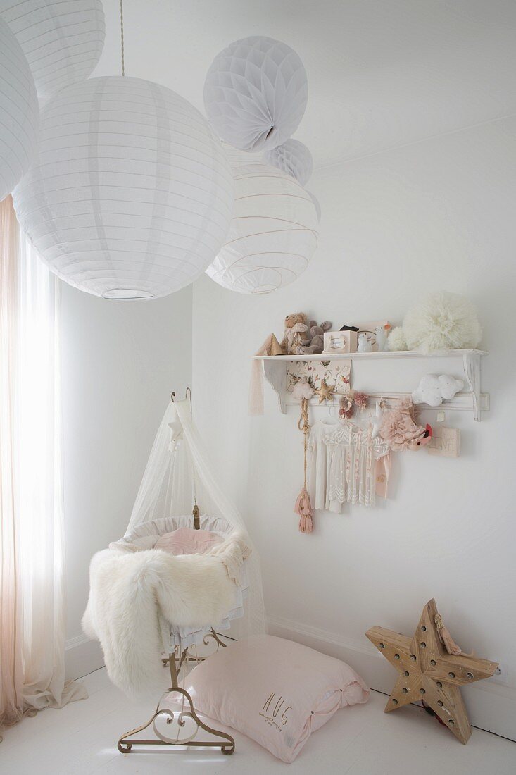 Paper lamps above cot in vintage-style nursery