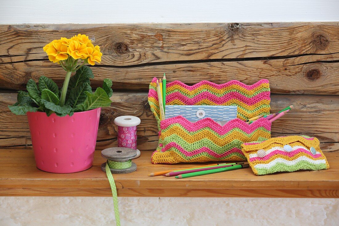 Two crocheted bags with colourful zigzag patterns