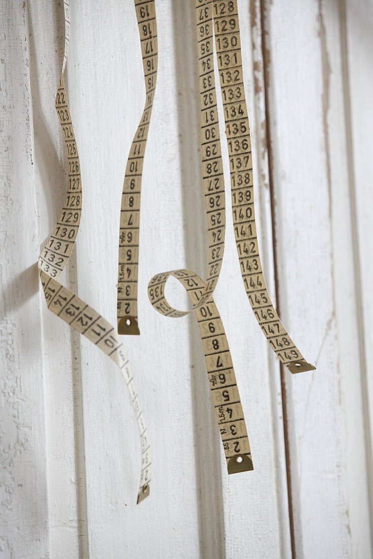 Old tape measures hung on board wall