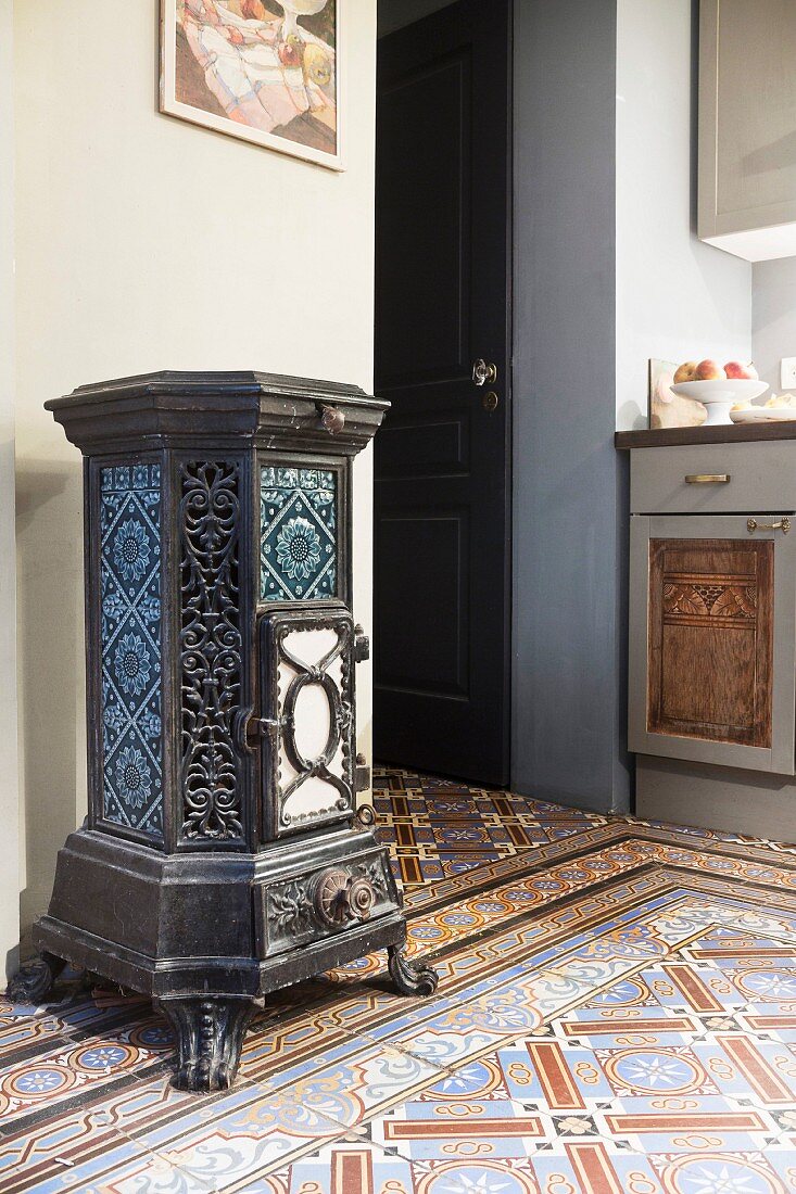 Antique, artistic, cast iron stove on patterned tiles