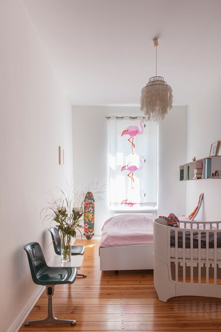 Babybett im Schlafzimmer mit Flamingovorhang und Wartebank