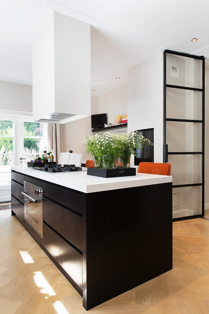 Large island counter with black cabinets and white worksurface