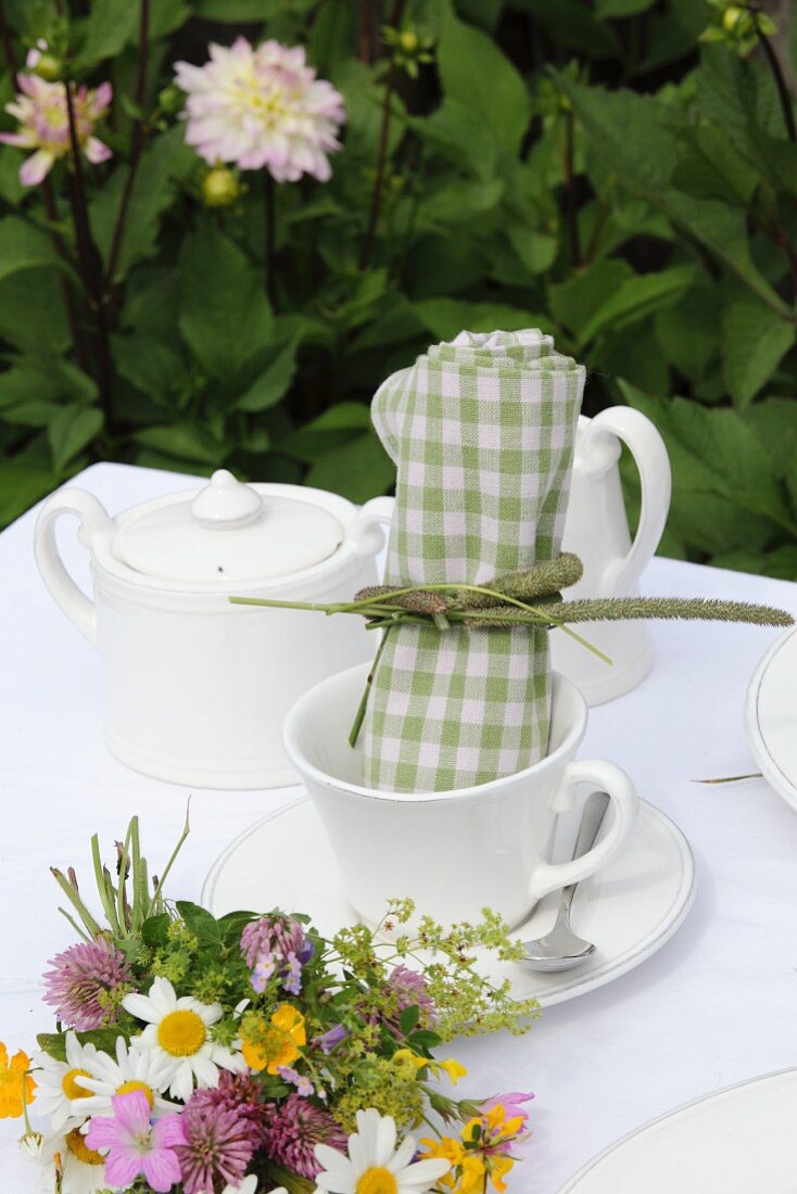 Green gingham linen napkin in white coffee cup