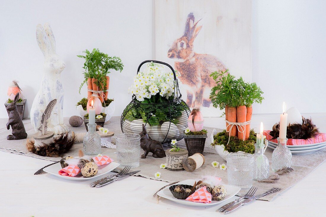 Festlich gedeckter Ostertisch mit dekorativen Gestecken und Hasenfiguren