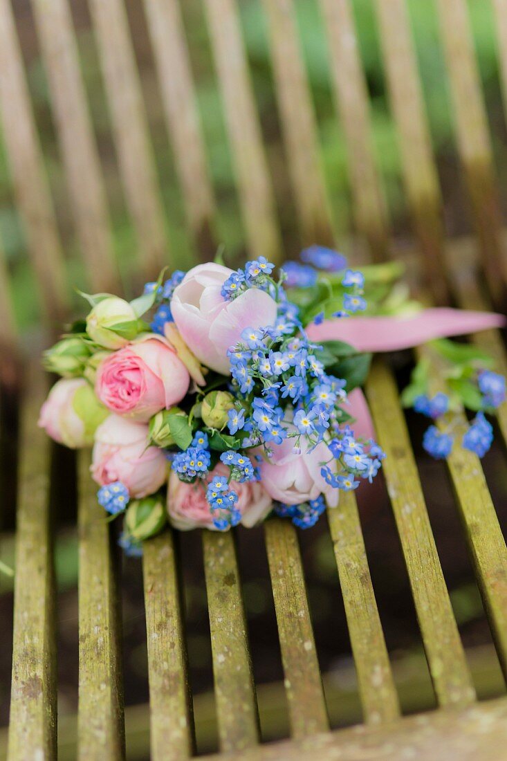 Posy of roses, tulips and forget-me-nots on garden chair