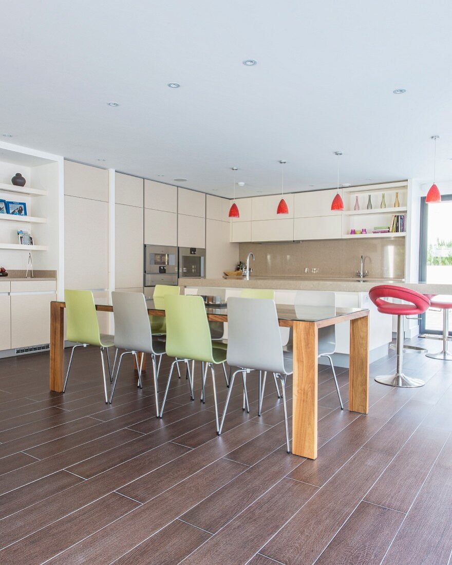 Moderner Esstisch mit bunten Stühlen in der offenen Küche