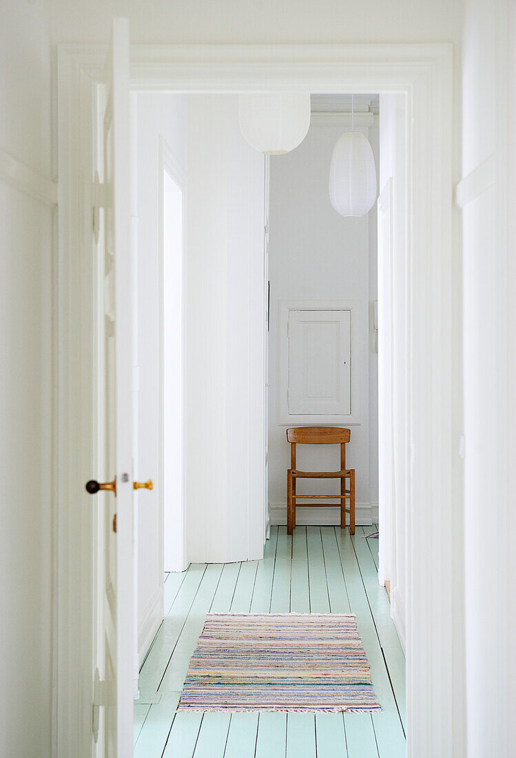Bright hallway with turquoise-colored floor and wooden chair