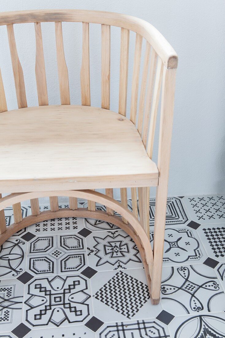 Semicircular chair on tiled floor with black and white pattern