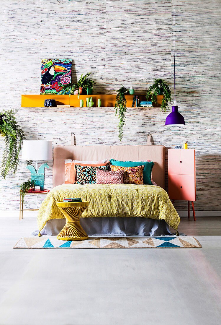 Wall board with colorful accessories over double bed in the bedroom with silk wallpaper