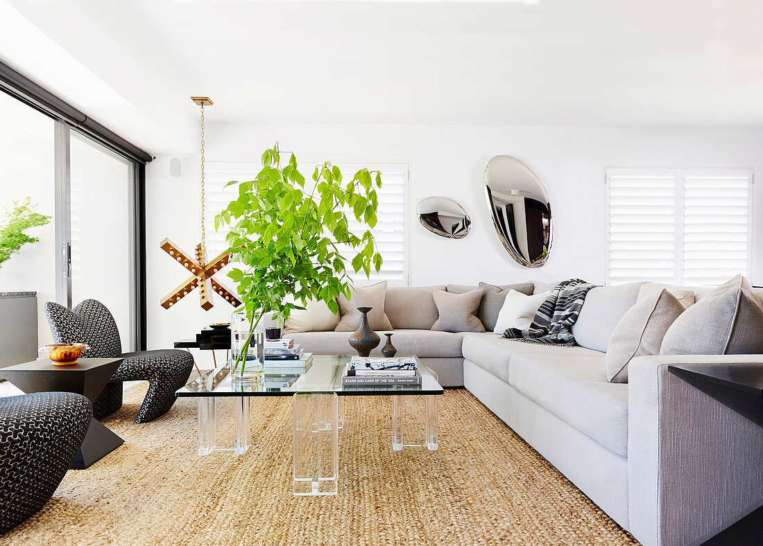 Transparenter Couchtisch und großes Sofa im modernen Wohnzimmer
