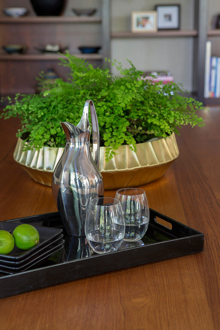Black tray with carafe and water glasses on the table