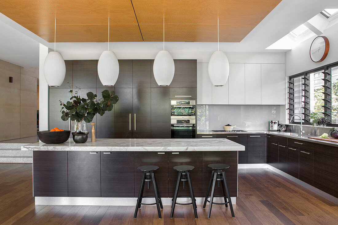 Moderne offene Küche mit dunklen Holzfronten und Kücheninsel