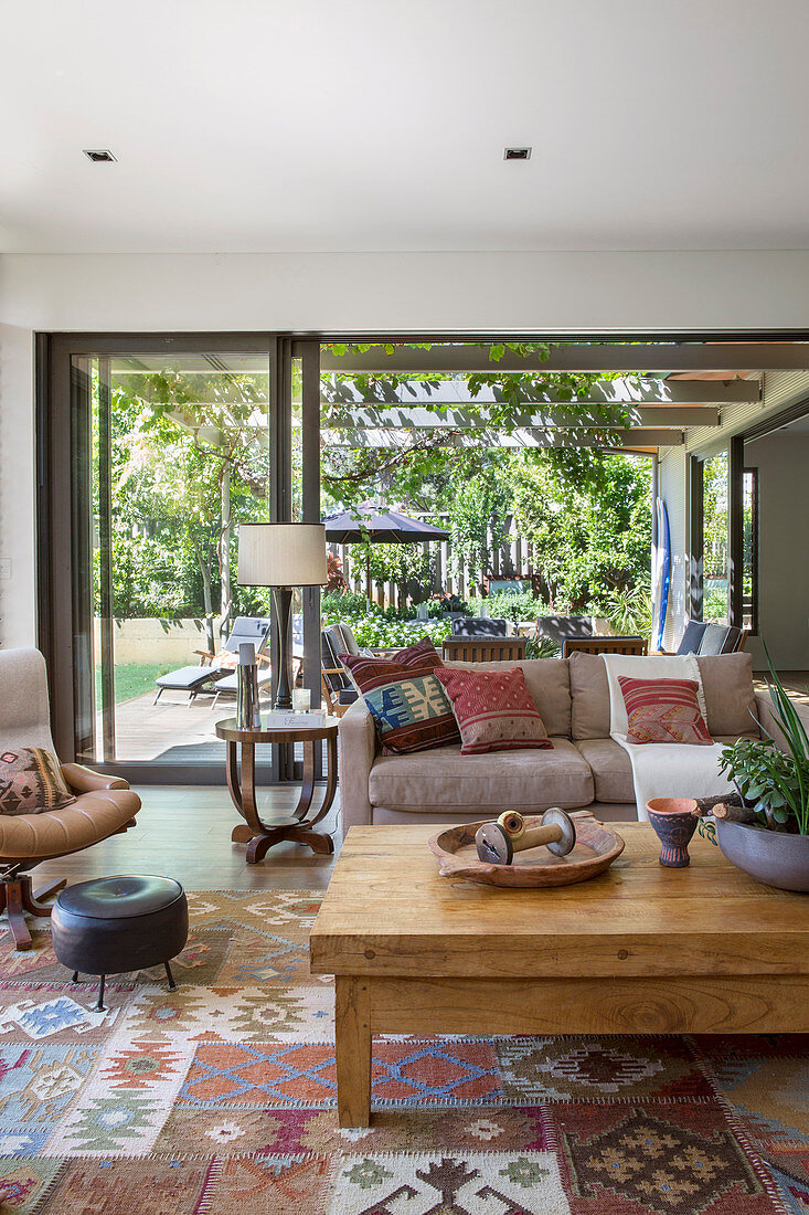 Living room in natural tones with an open glass front to the garden