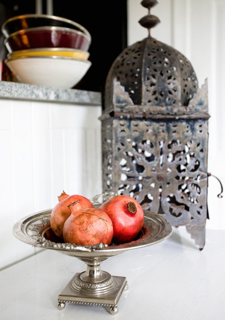 Silberschale mit Granatäpfeln vor einer orientalischen Laterne