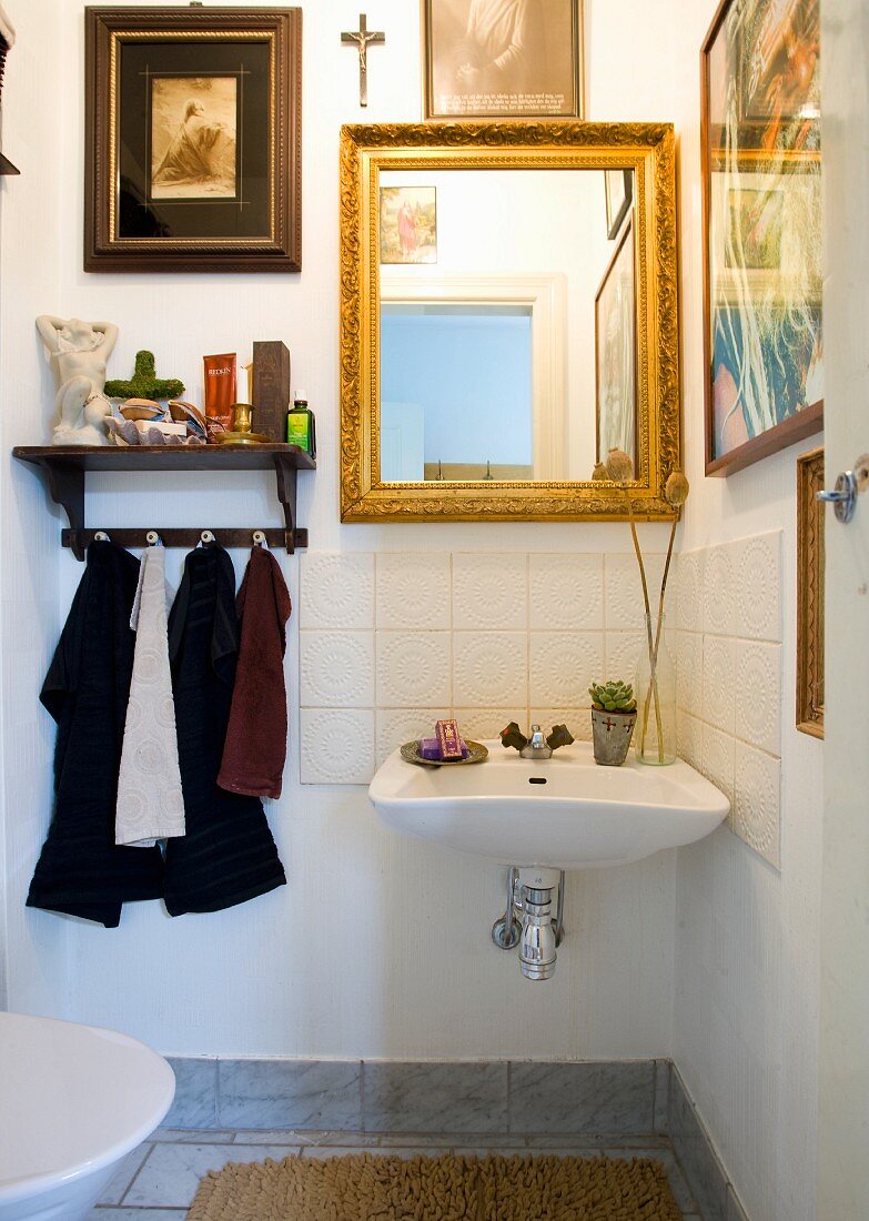 Guest toilet decorated with pictures and gilt-framed mirror
