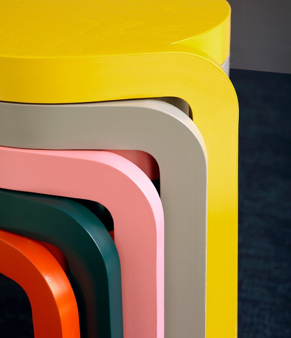 Legs of stacked nest of tables in bright, plain colours