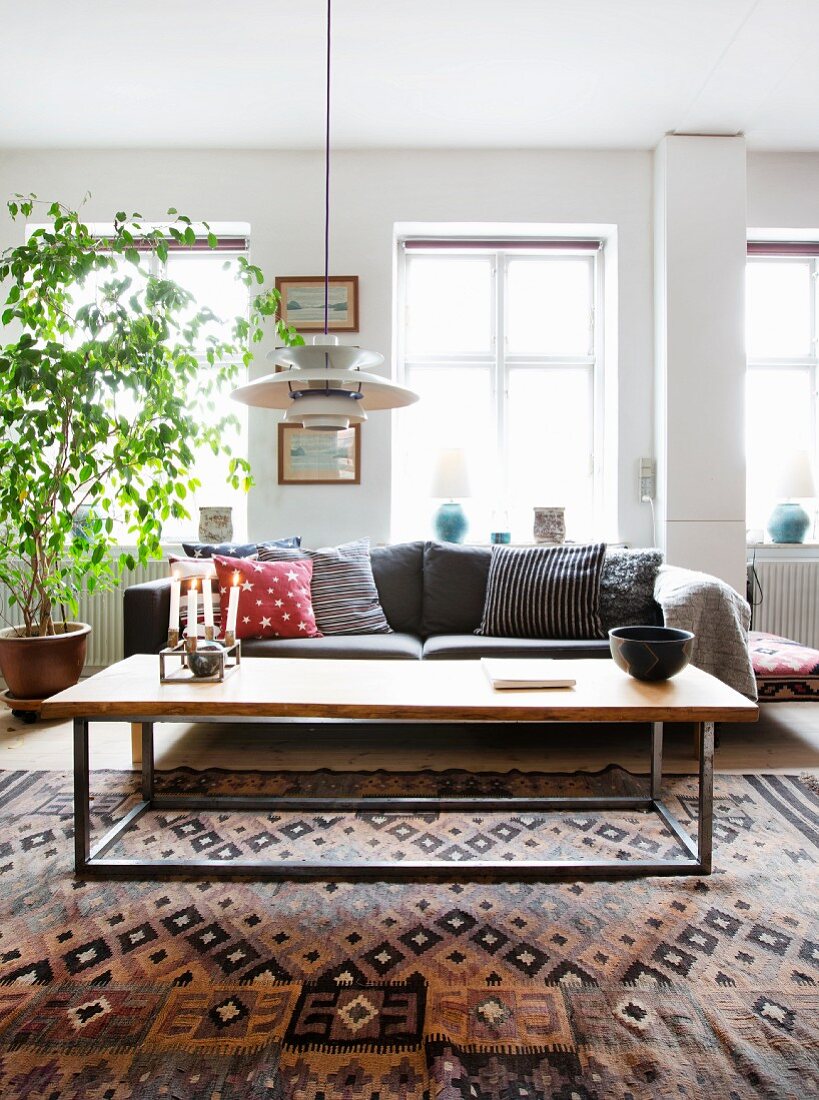 Coffee table with metal frame on woven rug in front of sofa