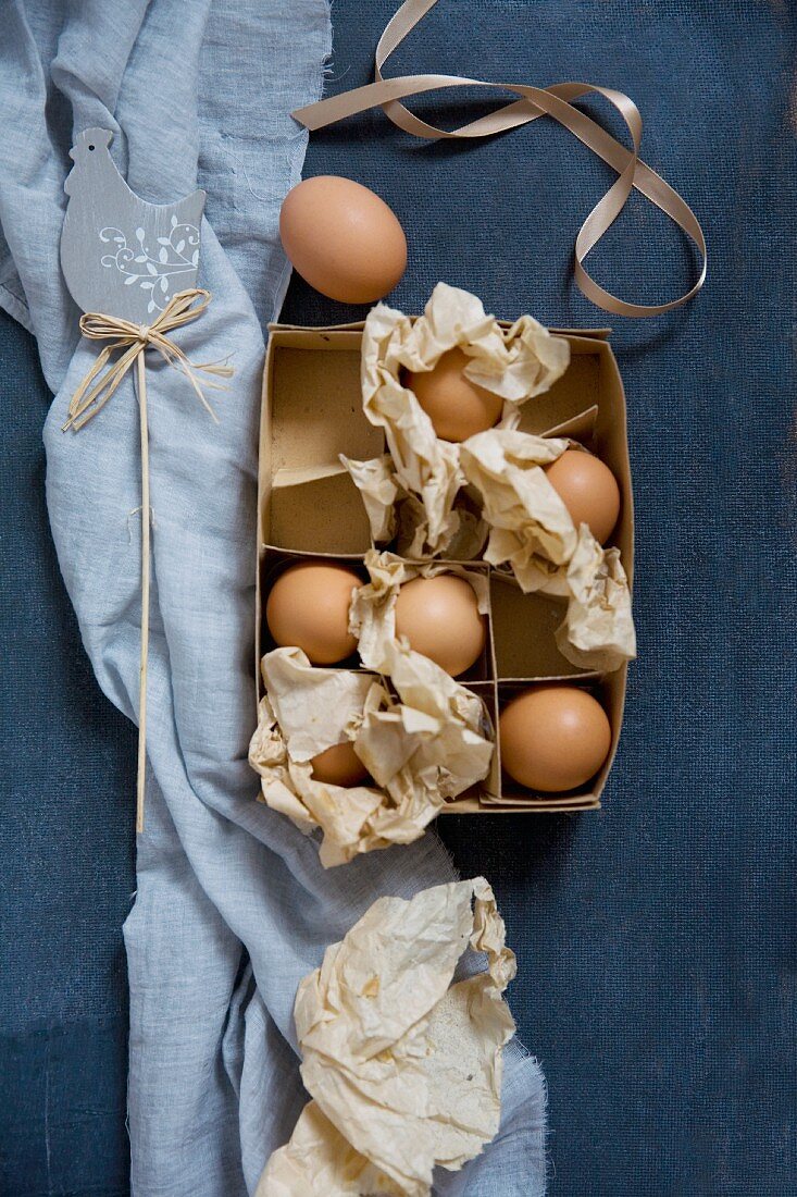 Eier in Vintage Pappschachtel mit zerknülltem Papier