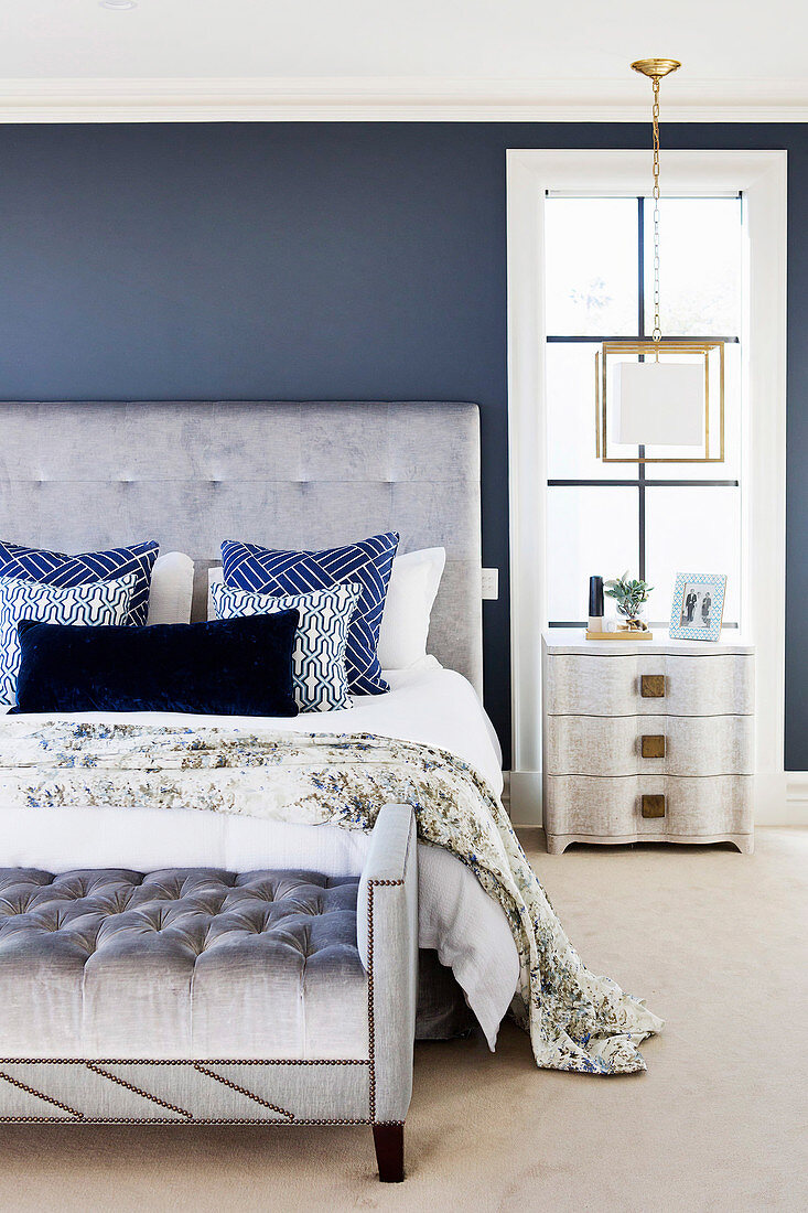 Elegantes Schlafzimmer mit grauem Polsterbett mit Polsterbank