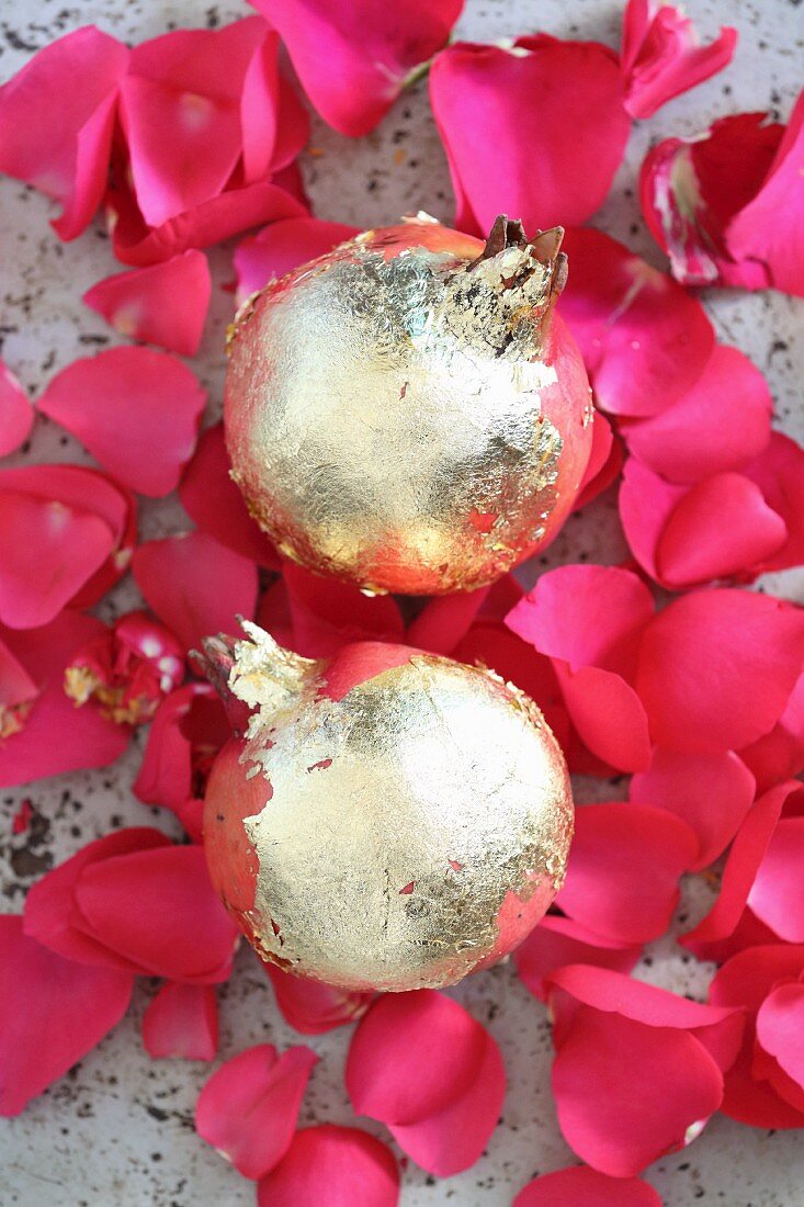 Pink rose petals and gilded pomegranates