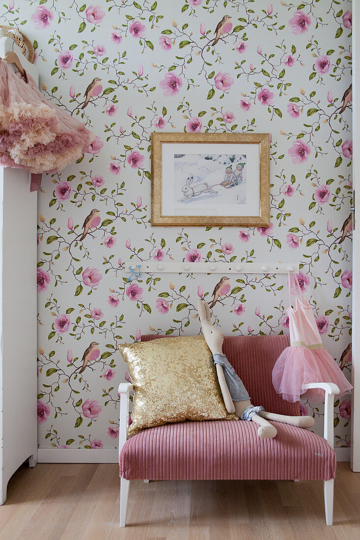 Pink couch against floral wallpaper in child's bedroom