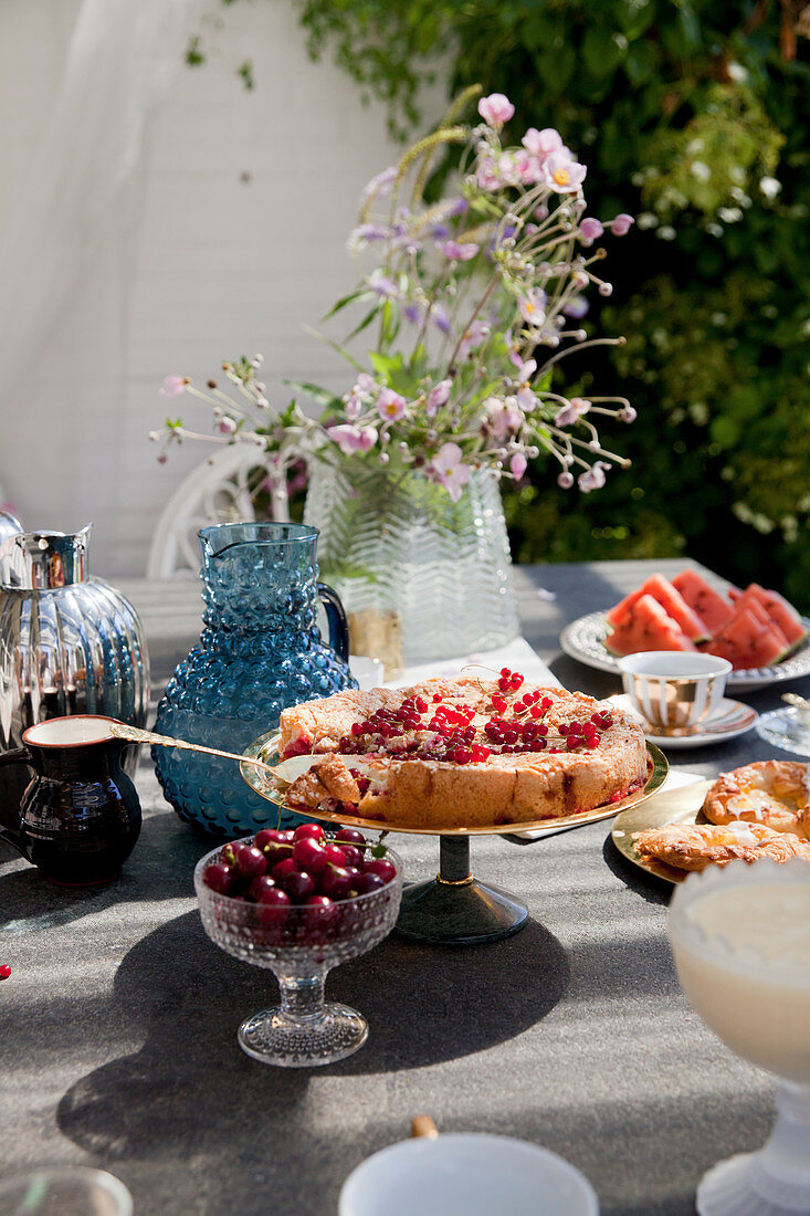 Redcurrant cake on set garden table in summer