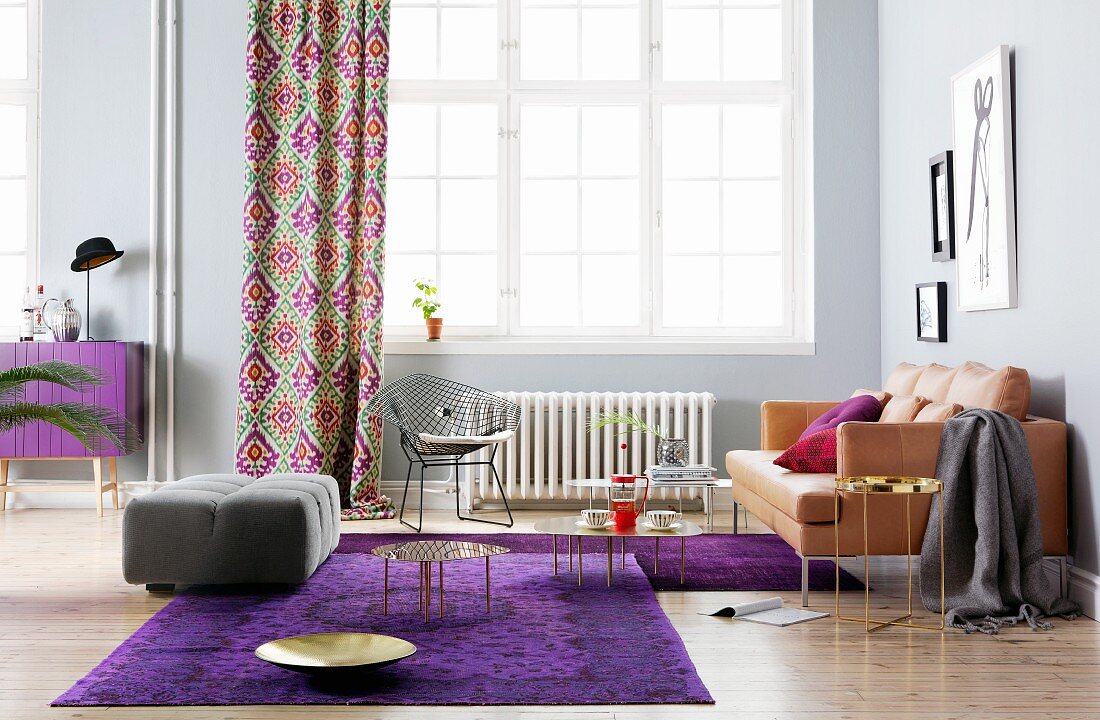Living room with leather sofa, purple rugs and purple sideboard