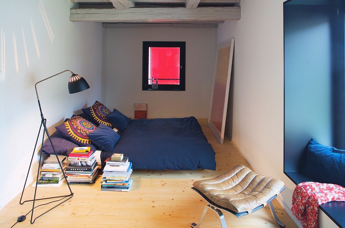 Schmales Schlafzimmer mit blauer Nische und Leseleuchte