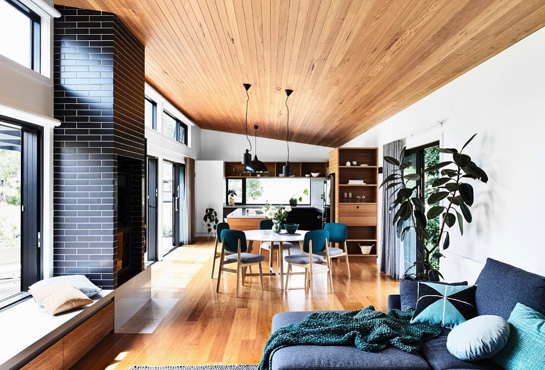 Open living area with parquet flooring, wooden ceiling and glass front to the terrace