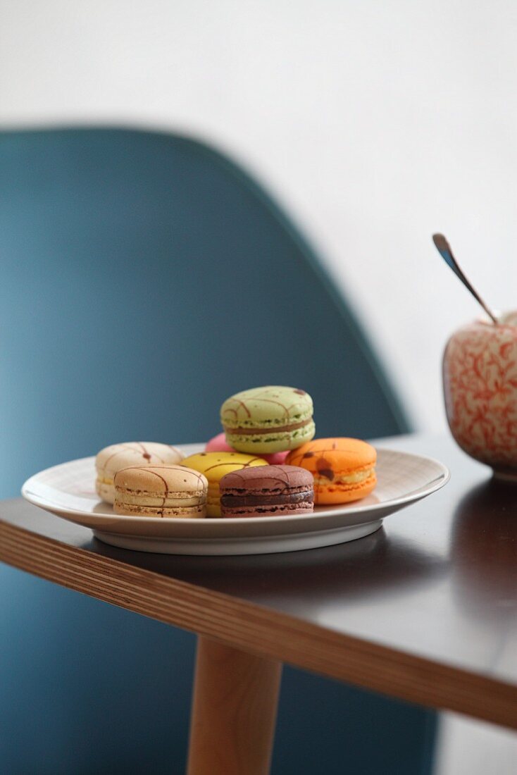 Plate of colourful macarons on table