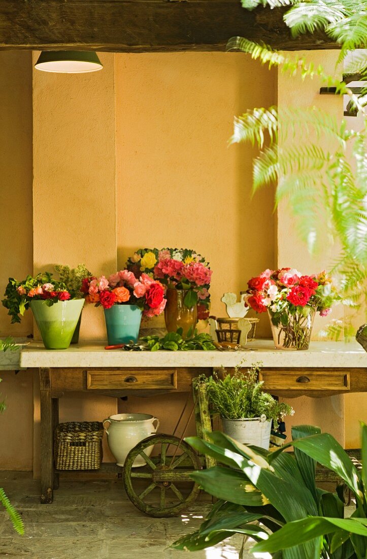 Tisch und bunte Blumensträusse auf Terrasse