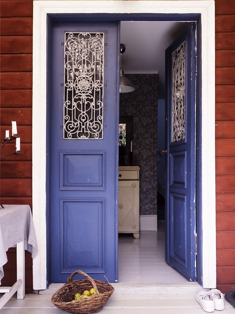 Offene, violette Eingangstür mit traditionellem Flair