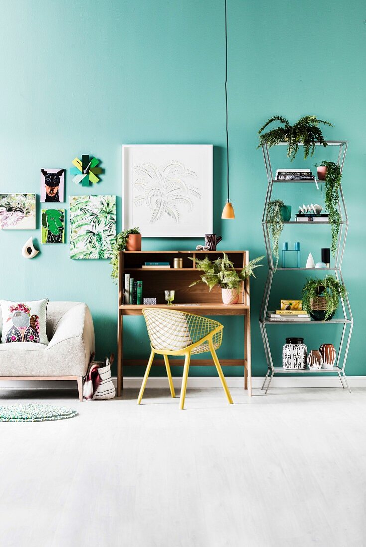 Sofa, secretary with shell chair and metal shelf with house plants, pictures of plant and animal motifs on green wall